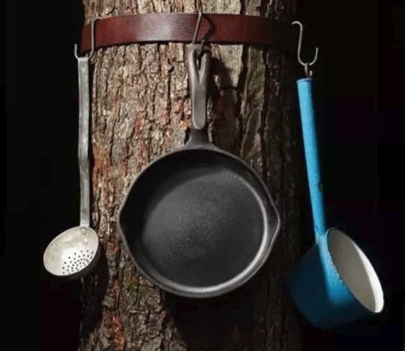 belt over tree to hold pots and pans on campsite