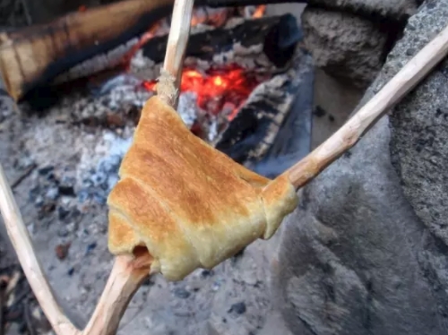 cook dough on stick over campfire