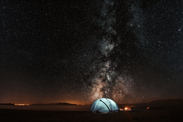 Beautiful campsite for beginners underneath the stars with a single orange tent