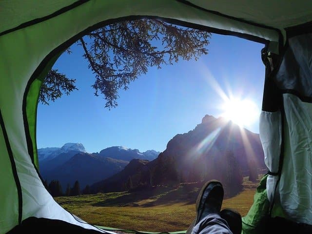 open camping tent overlooking a mountain and nature