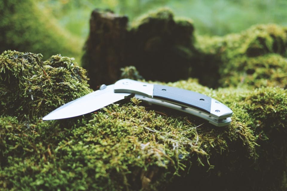 camping knife on green moss