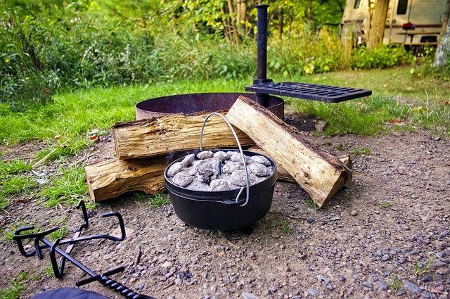 dutch oven with coals over an open campfire