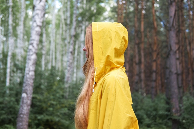 woman camping with a raincoat in rainy weather