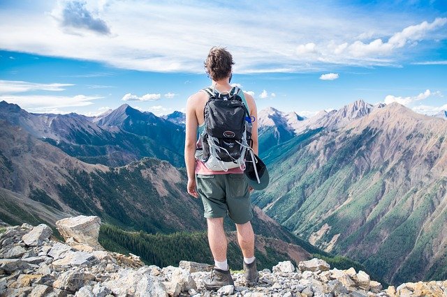 man hiking and camping on a mountainside with a bag on his back